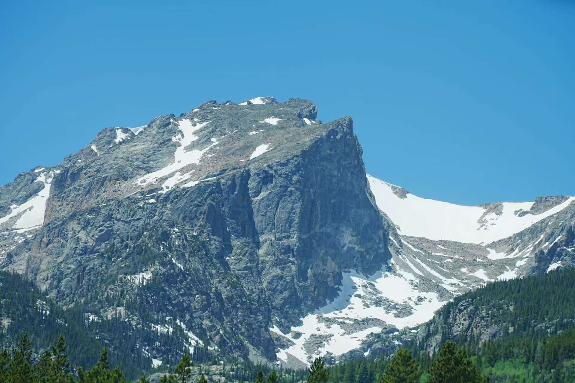 Snow-streaked mountain under a blue sky